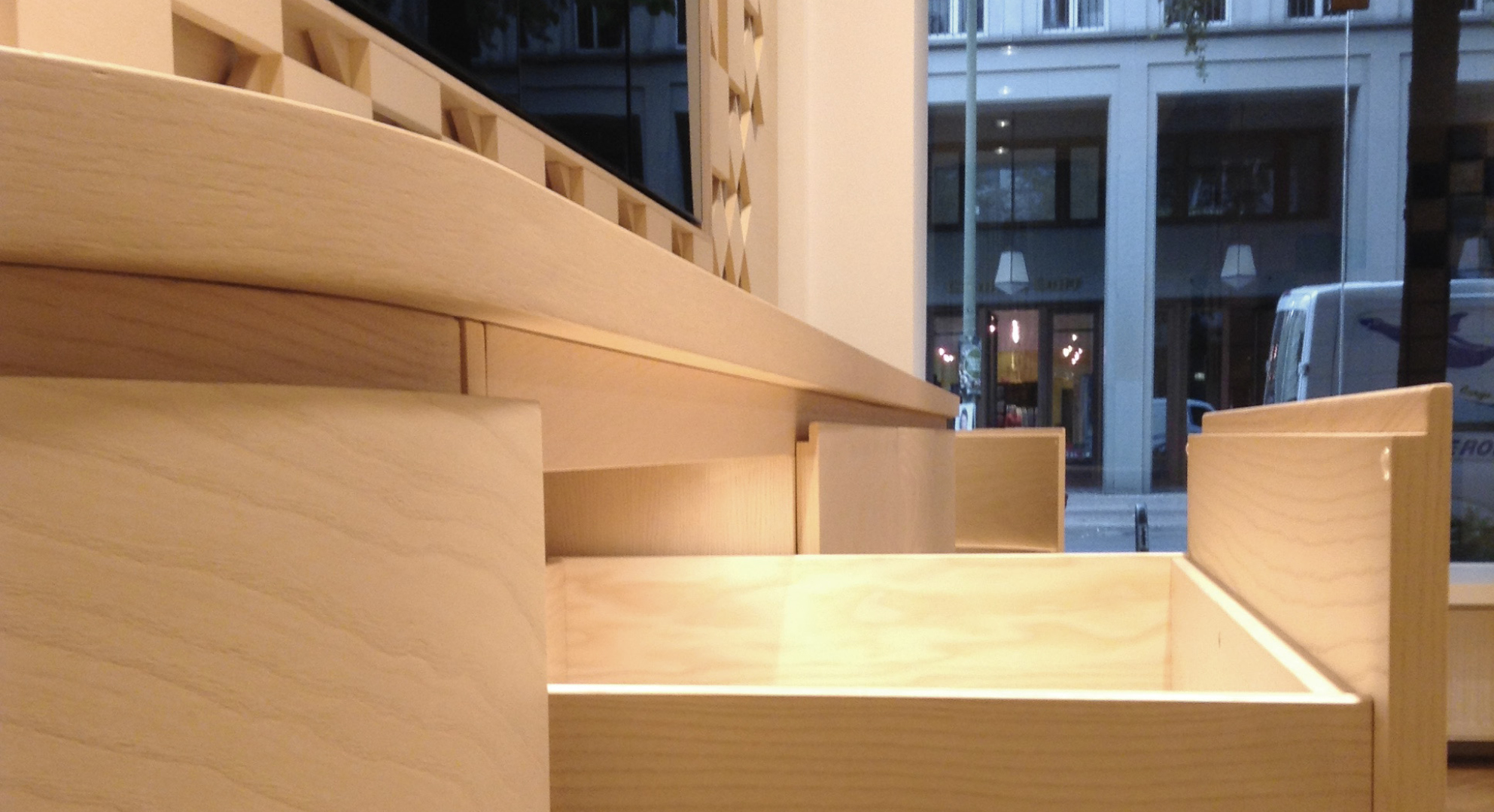 Ladengeschäft, Retail Design, Sideboards mit gebogenen Elementen,  Präsentationsflächen und 3D Reliefs beleuchtet, Polsterelemente mit Kvadrat Stoff, multifunktionales Touchpaneel Tresen, Esche Furnier und Massivholz hell gebeizt und matt lackiert